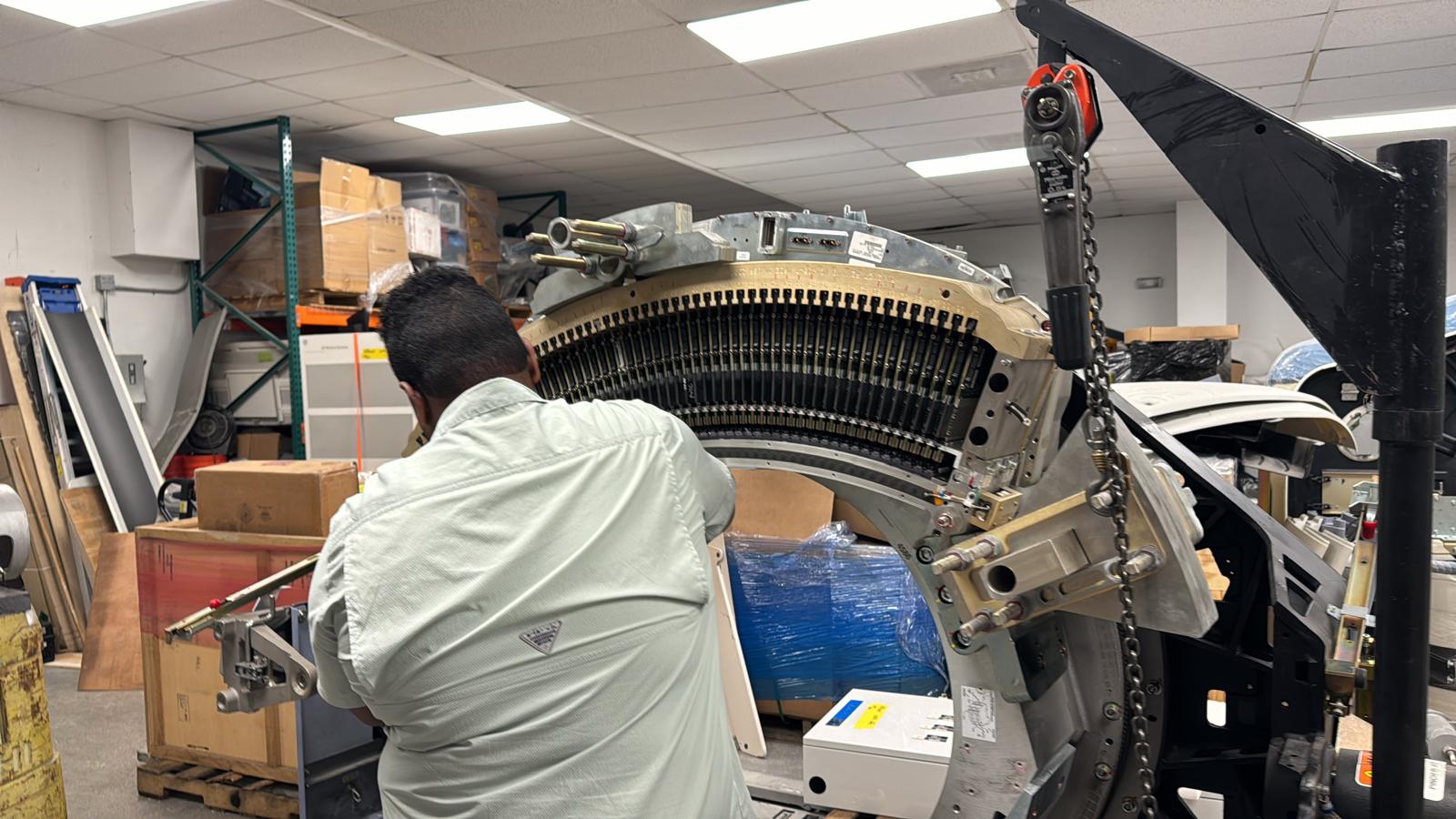 Technician working on an open CT gantry during equipment service.