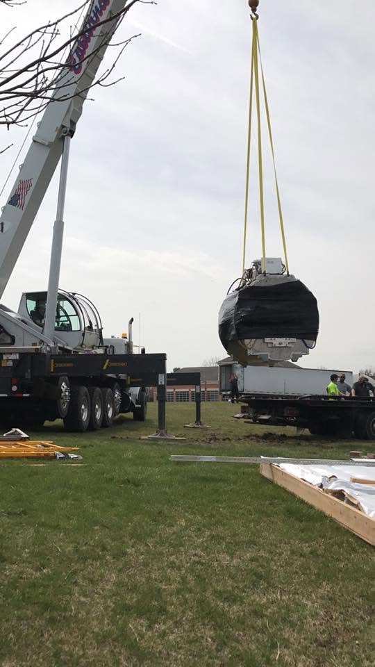 MRI magnet being lifted by crane during an equipment relocation.